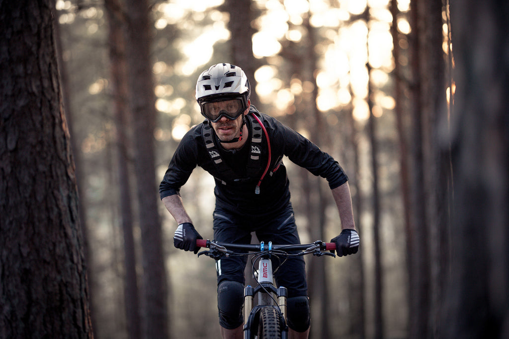 Man riding mountain bike wearing black downhill mountain bike protective glasses